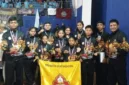 Pelatih dan atlet pencak silat Perisai Diri Kabupaten Rote Ndao berfoto bersama usai menerima piala juara umum pada ajang Kejuaraan Internasional Pencak Silat Paku Bumi Open XIV di GOR Lembah UGM, Yogyakarta, 6 April 2026.