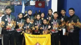Pelatih dan atlet pencak silat Perisai Diri Kabupaten Rote Ndao berfoto bersama usai menerima piala juara umum pada ajang Kejuaraan Internasional Pencak Silat Paku Bumi Open XIV di GOR Lembah UGM, Yogyakarta, 6 April 2026.